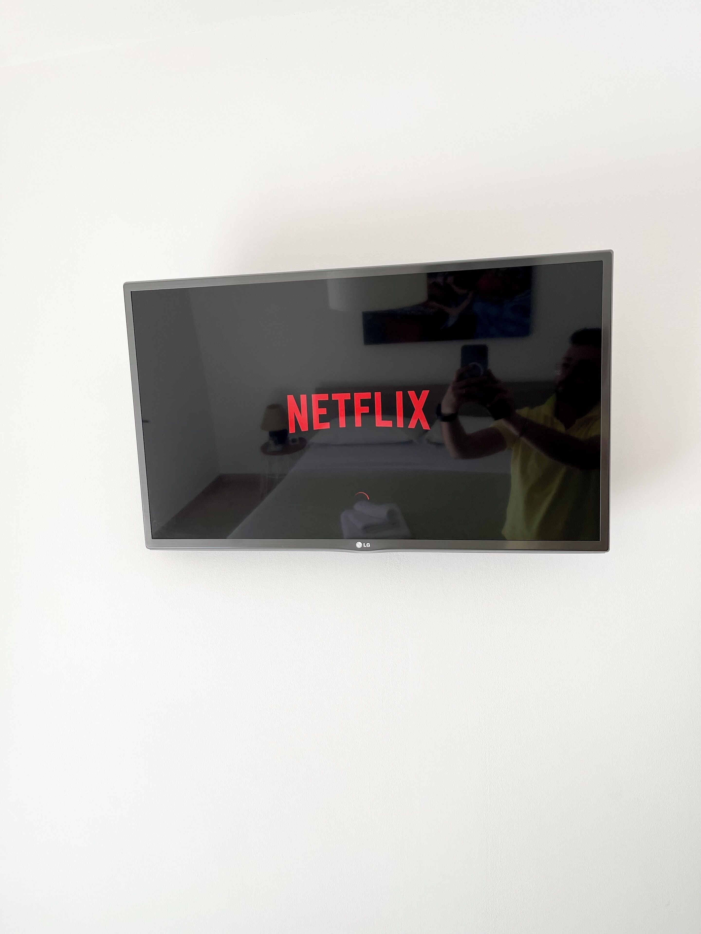 Un televisor de pantalla plana montado en la pared con la palabra "NETFLIX" mostrada en la pantalla.
