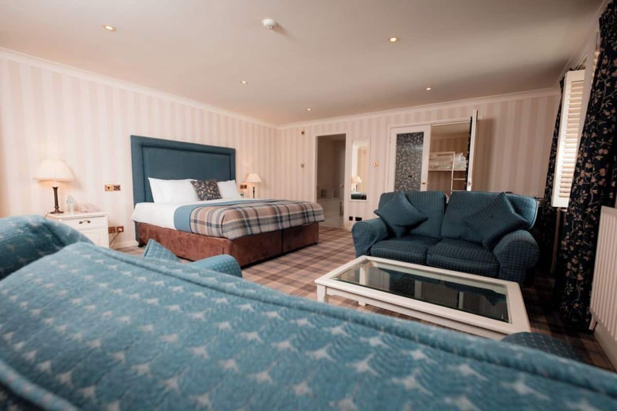Ein Hotelzimmer mit Bett, Sofa, Couchtisch und Kleiderschrank.