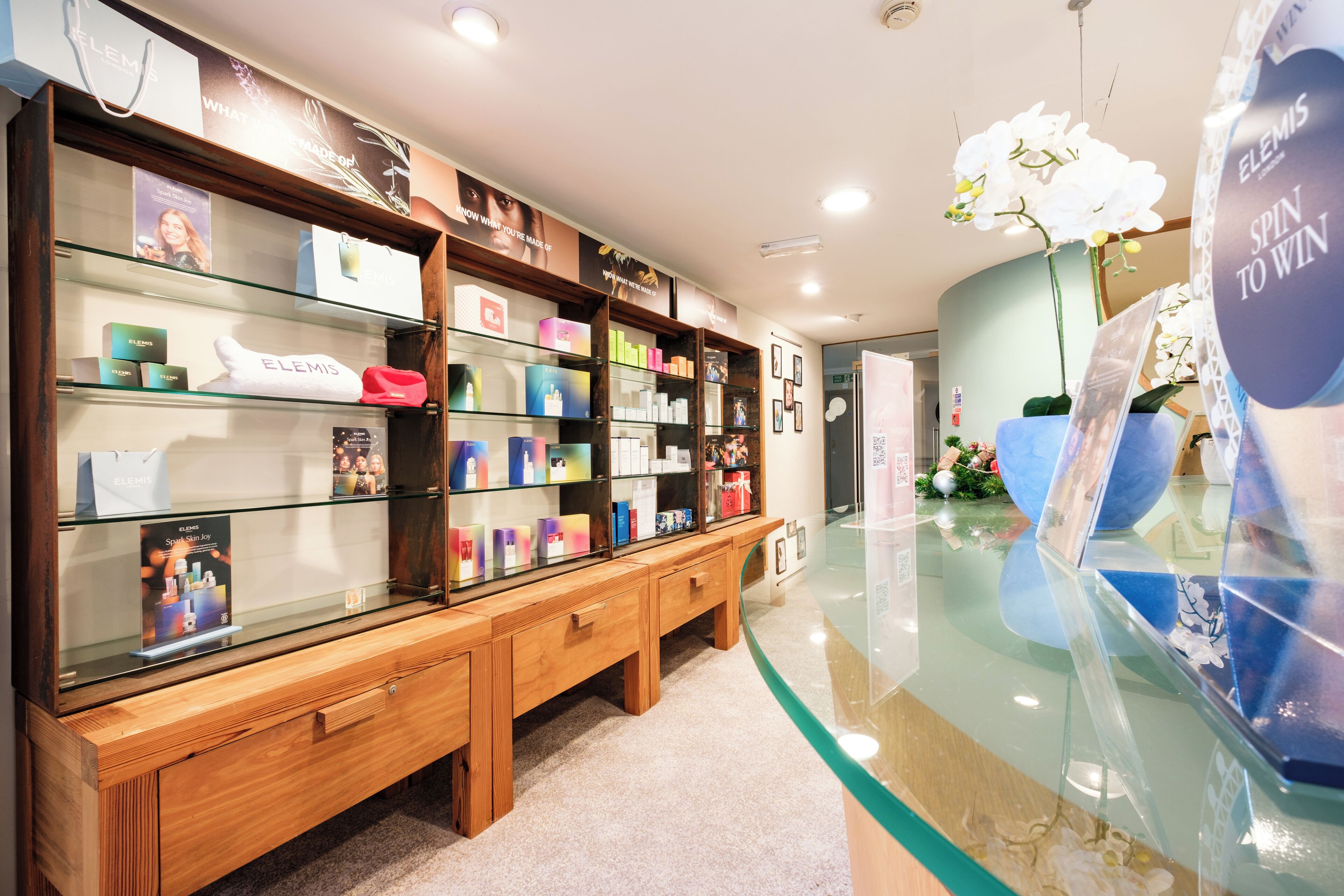A retail store with glass display cases and wooden shelving.