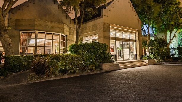 A building with a large glass facade, a brick exterior, and a well-lit entrance.