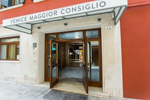 La entrada al hotel Venice Maggior Consiglio, con un cartel sobre la puerta y una placa con un número en la pared.