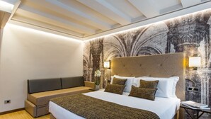 A modern hotel room with a large bed, a sofa, and a wall mural. - Venice Maggior Consiglio (Venice)
