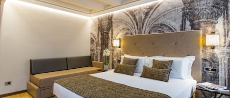 Una habitación de hotel moderna con una cama grande, un sofá y un mural en la pared.