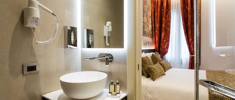 Un baño moderno con un lavamanos grande y blanco, un secador de pelo y un espejo.
