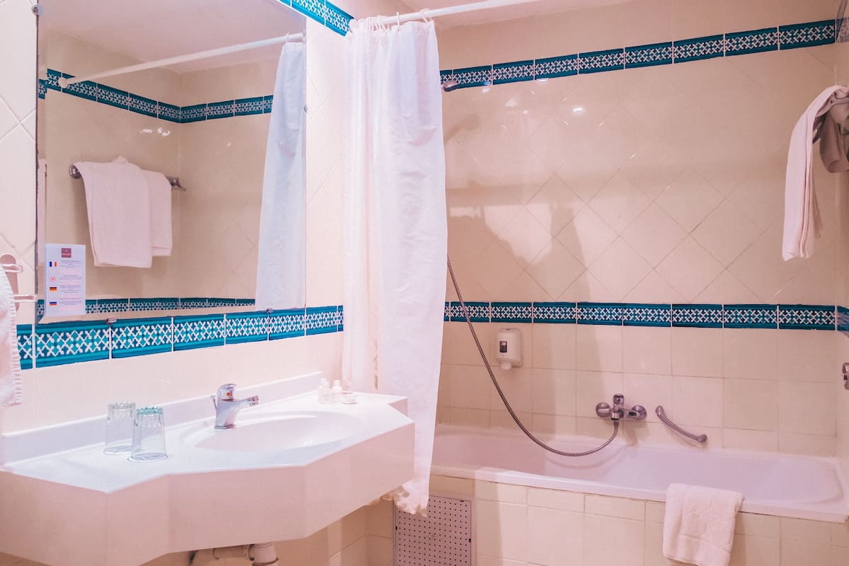 separate bathtub and shower, hair dryer, towels, soap