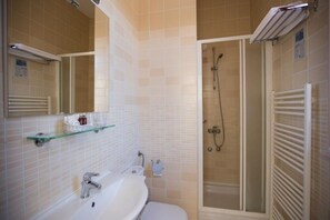 A bathroom with a white sink, mirror, and glass shower enclosure. - Hotel Zagreb (Dubrovnik)