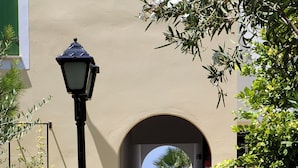 Un sendero que lleva a una playa, con un farol y un arco.