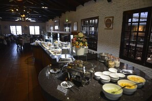 Una mesa de buffet con diversos alimentos y utensilios.