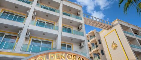 A multi-story hotel with balconies and a prominent "Golden Orange" sign.
