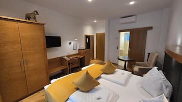 Ein Hotelzimmer mit Bett, Schreibtisch, Stuhl und Kleiderschrank.