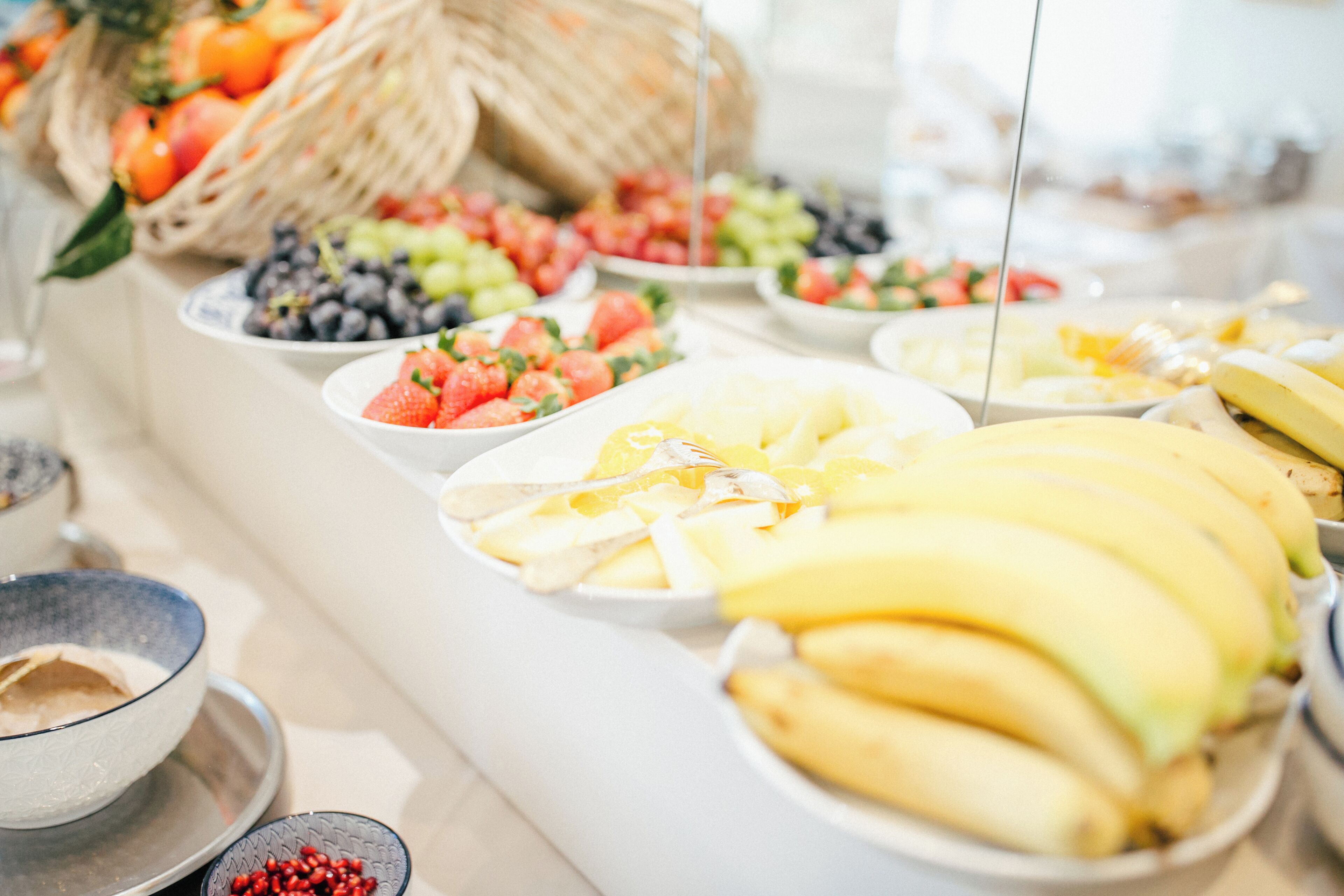 Una mesa de buffet con varias frutas y una cesta de mimbre.