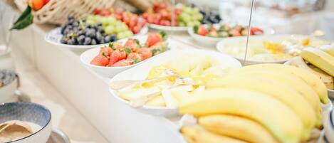 Una mesa de buffet con varias frutas y una cesta de mimbre.