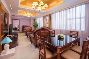 A formal dining room with a glass table, wooden chairs, and a chandelier. - Xinyuan Hot Spring Hotel (Haikou)