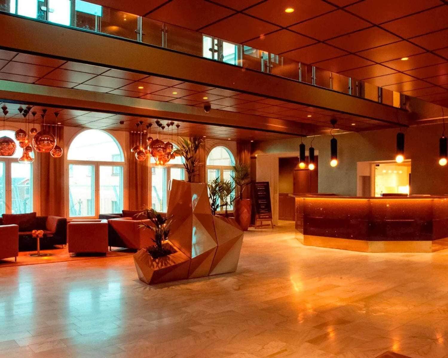 A spacious lobby with a reception desk, seating area, and large windows.