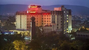 Un edificio de varios pisos con un letrero llamativo que dice "RAMADA".