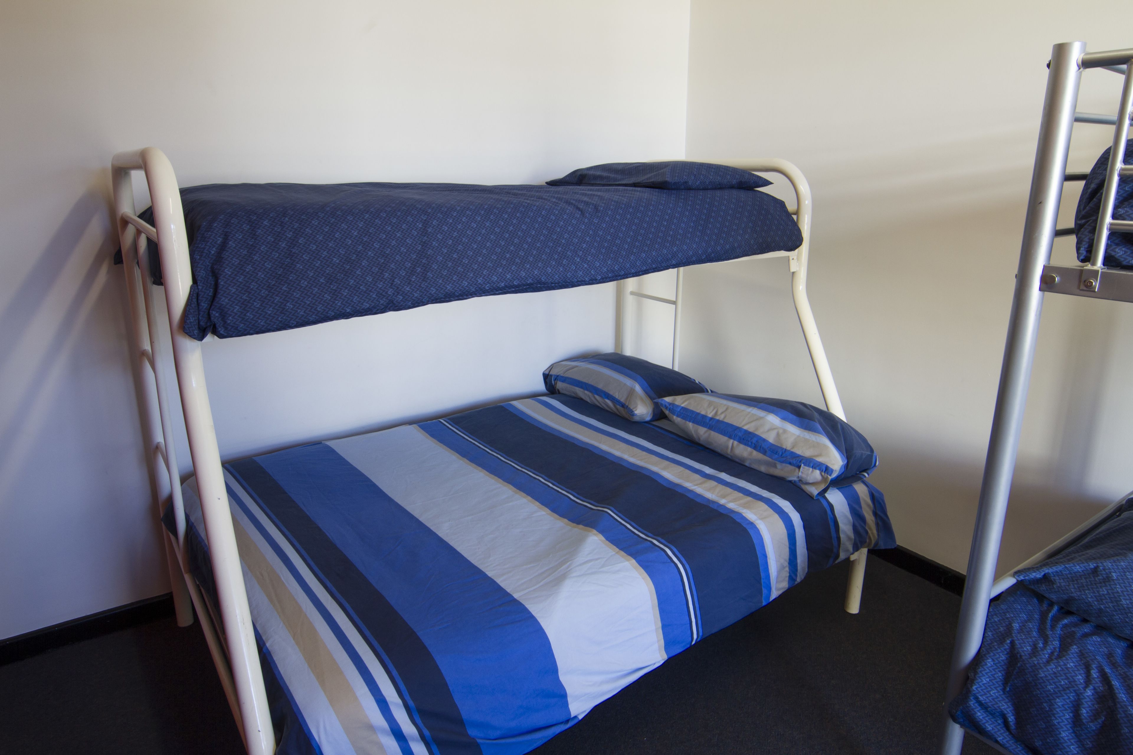 A bunk bed with a blue and white striped bedding.