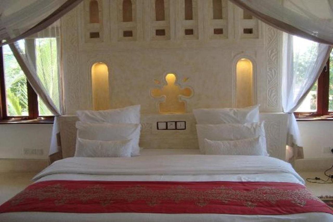 A bed with a canopy, two wall-mounted lights, and a decorative wall panel.