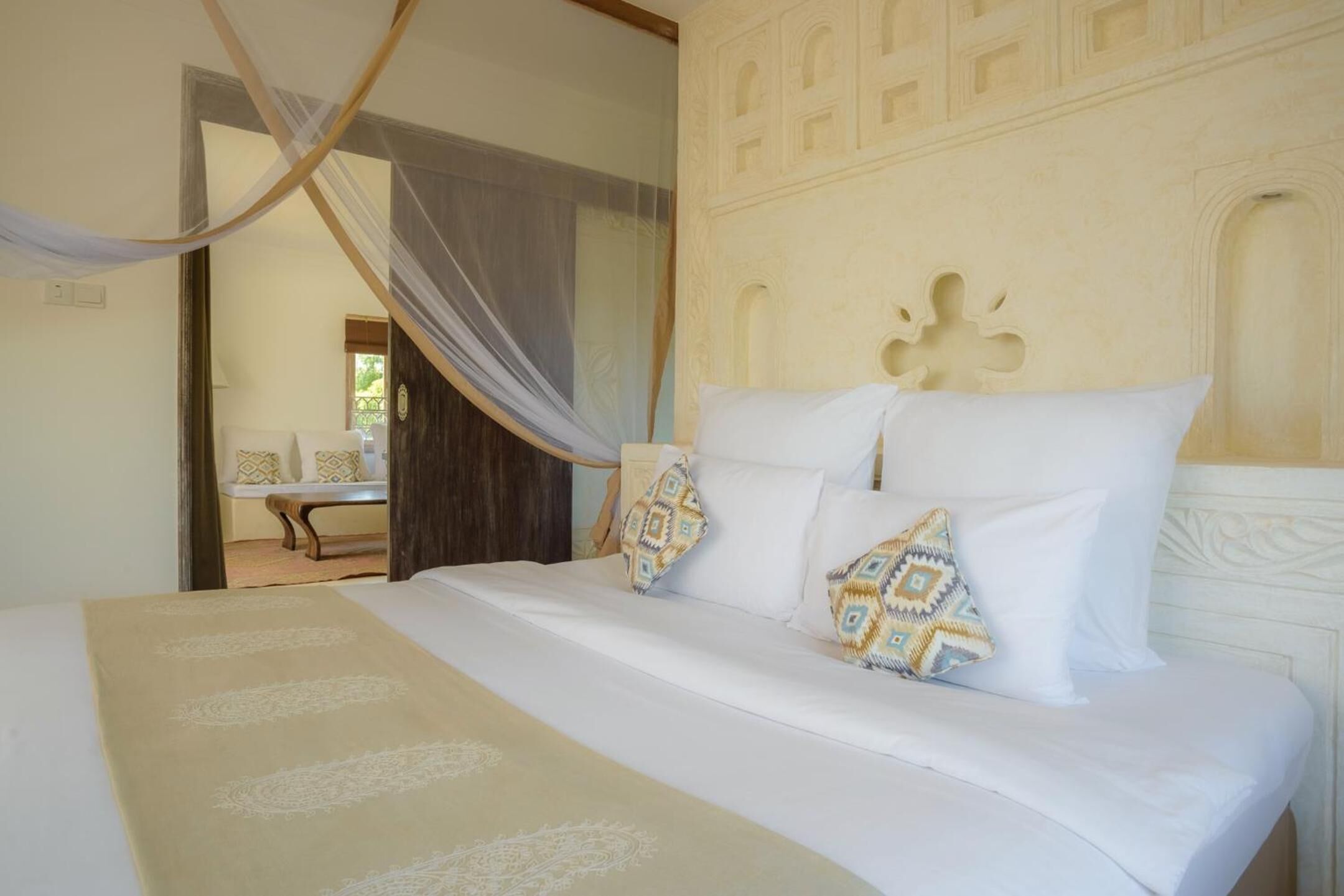 A bedroom with a bed, a canopy, and a decorative headboard.