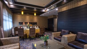 A modern dining area with a high ceiling, recessed lighting, and a central dining table surrounded by chairs. - Huashi Hotel (Guangzhou)
