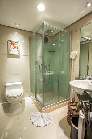 A modern bathroom with a glass-enclosed shower, a toilet, a sink, and a hairdryer. - Huashi Hotel (Guangzhou)