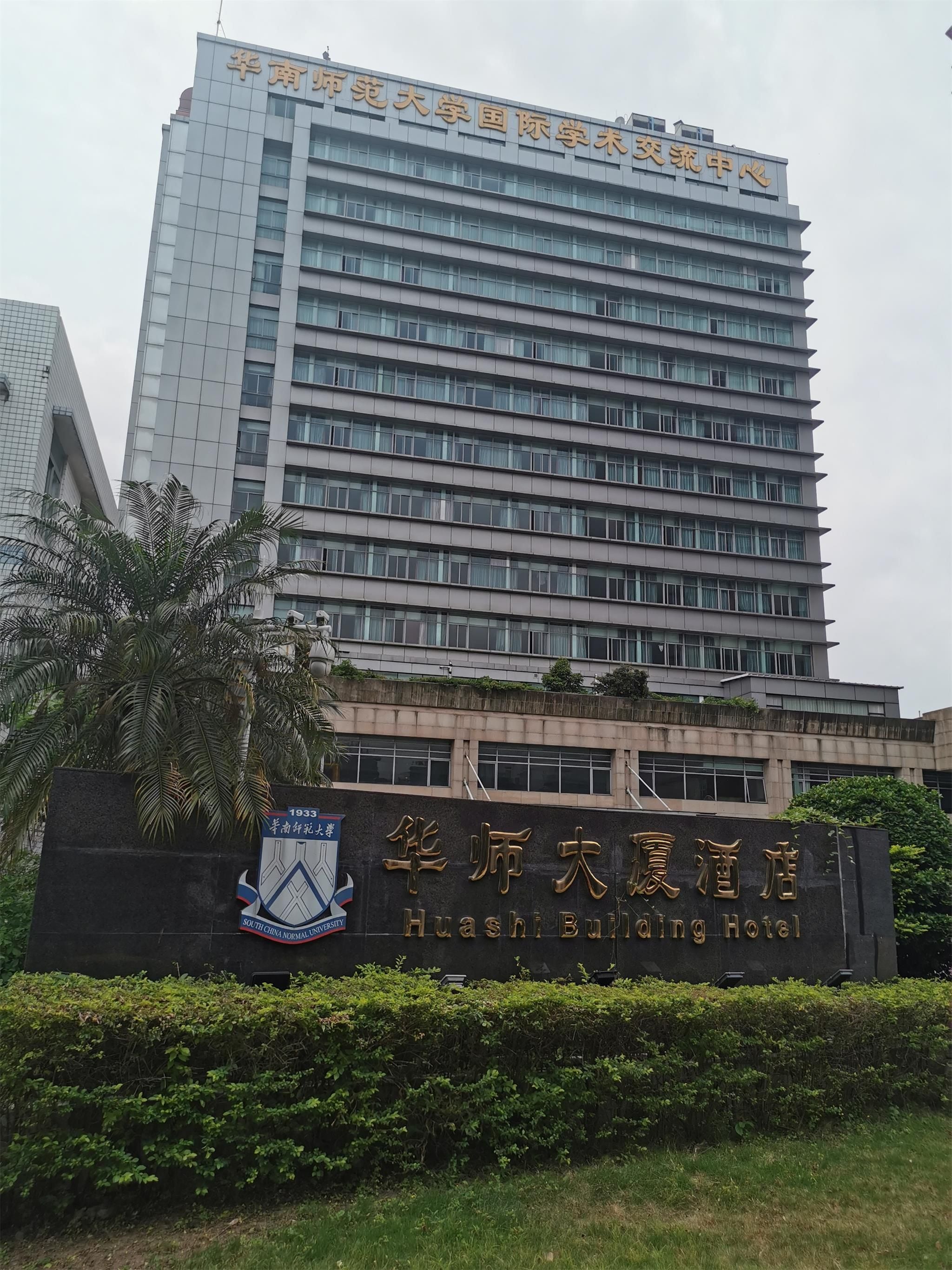 A multi-story building with a sign for Huashi Building Hotel.