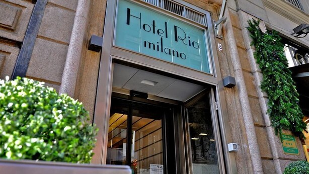 The exterior of Hotel Rio Milano with a clear entrance, a signboard, and a green sign indicating the hotel name. - Hotel Rio (Milan)