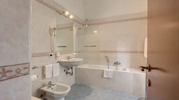 Een badkamer met een wastafel, toilet en bad.