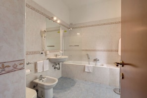 Un baño con lavamanos, inodoro y bañera.