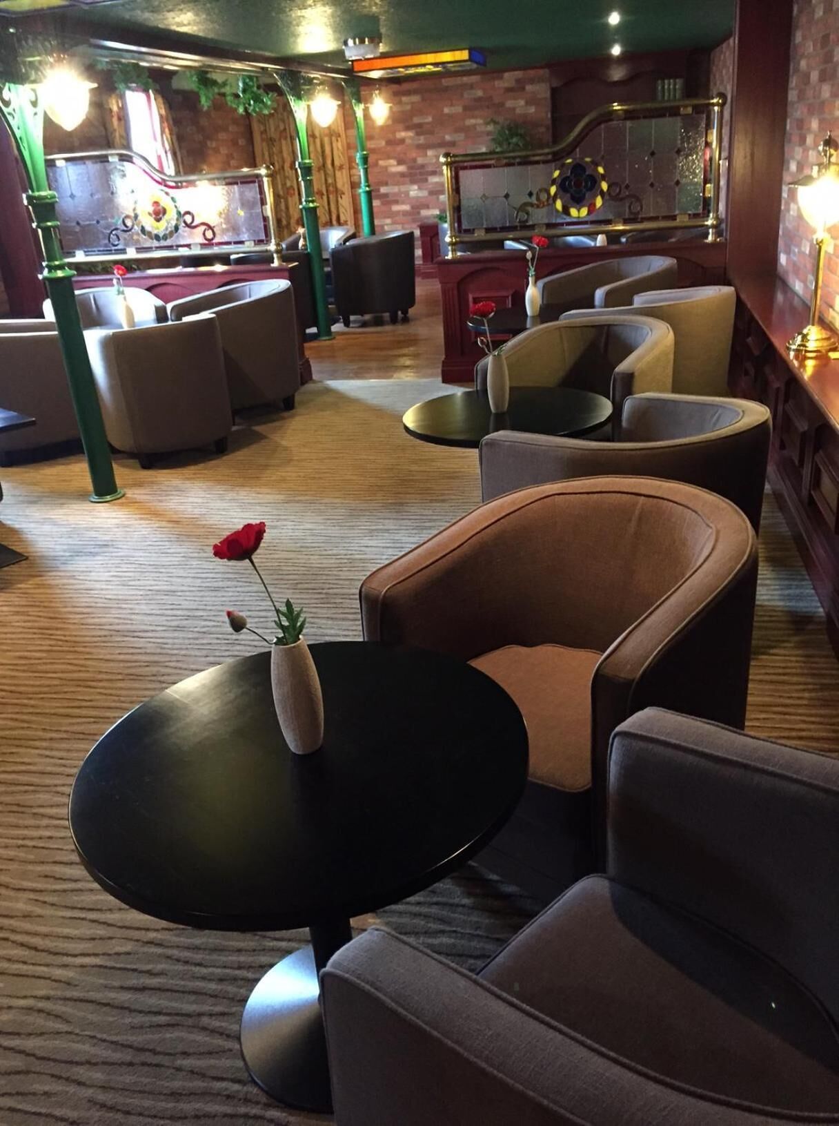 A cozy lounge area with comfortable seating and a small table with a vase of flowers.