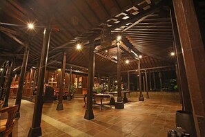 An indoor space with a high ceiling, wooden beams, and multiple light fixtures. - Mesastila Resort and Spa Magelang (Losari)