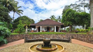 A building with a tiled roof, surrounded by a stone wall and lush greenery. - Mesastila Resort and Spa Magelang (Losari)