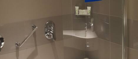 Une salle de bain moderne dotée d’une douche à parois de verre, d’une baignoire sur pieds et d’un motif décoratif représentant un paysage urbain sur le mur.