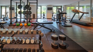 Une salle de sport équipée de matériel de musculation, de tapis de course et d’appareils d’exercice.