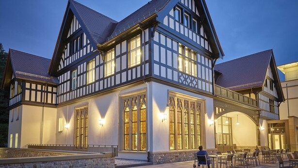 Un bâtiment traditionnel à colombages, doté de grandes fenêtres et d’une façade en pierre.