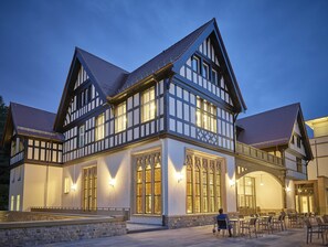 Ein traditionelles Fachwerkhäuschen mit großen Fenstern und einer Steinfassade.