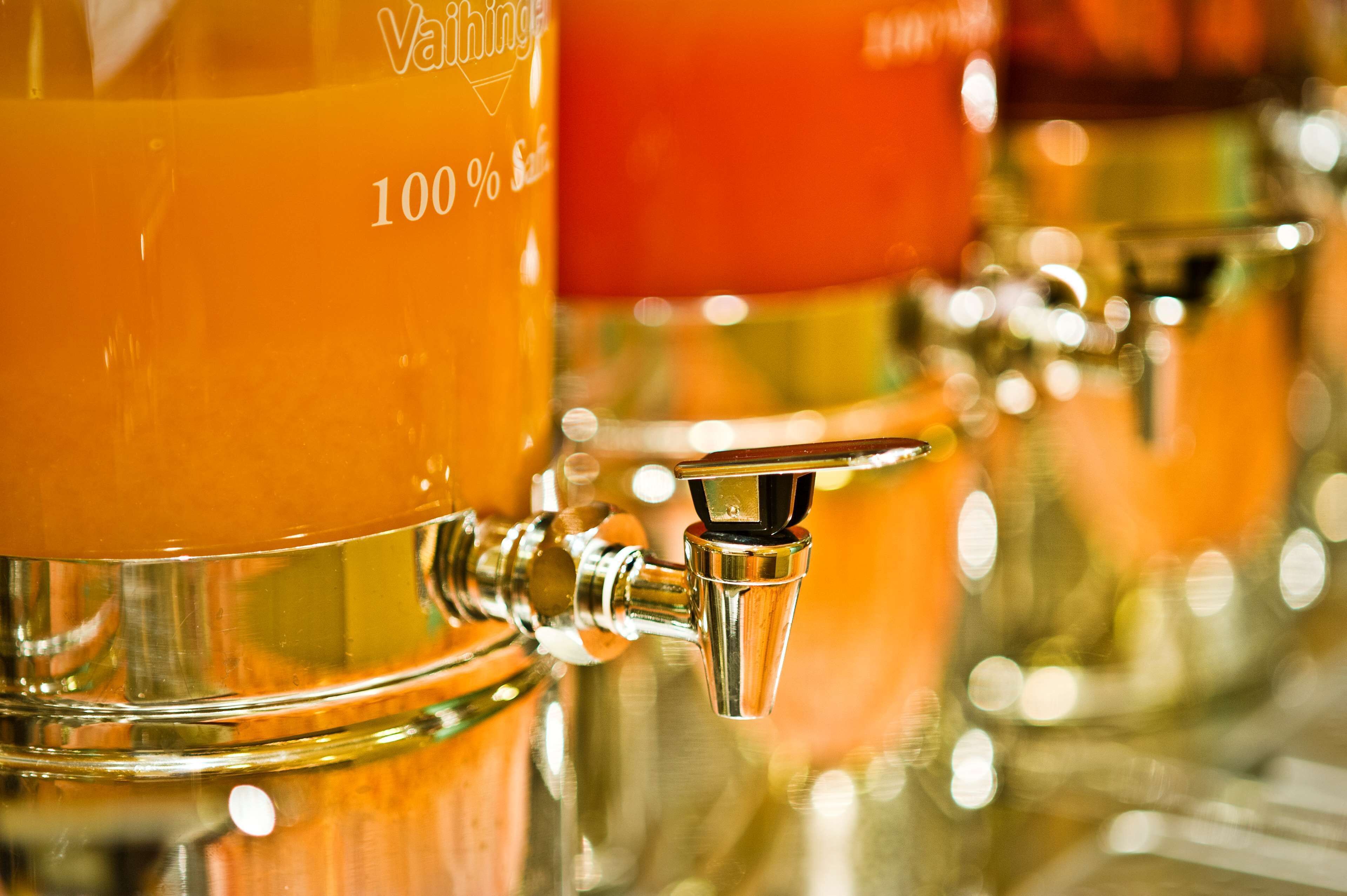 A close-up of a tap with a glass container labeled "100%".