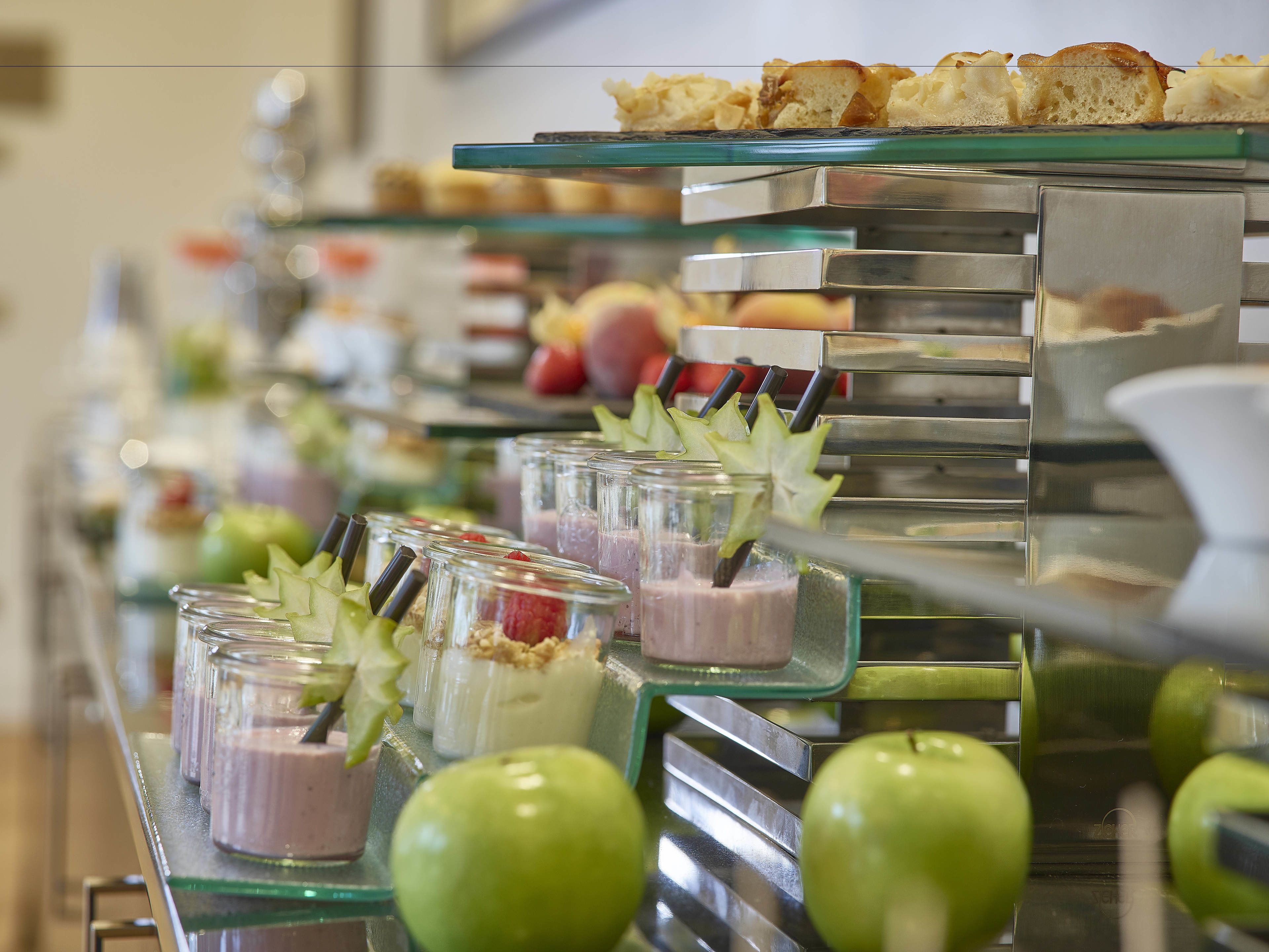 Een buffet met diverse gerechten, waaronder desserts en fruit.