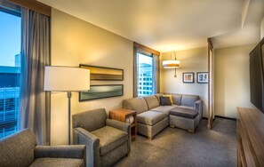 A hotel room with a sofa set, a small table, a lamp, and a TV. - Hyatt Place Washington DC/National Mall (Washington)