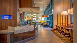 A modern hotel lobby with a reception desk, seating area, and large windows. - Hyatt Place Washington DC/National Mall (Washington)