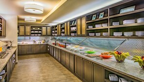 A modern kitchen with wooden cabinets, a buffet counter with various food items, and a tiled backsplash. - Hyatt Place Washington DC/National Mall (Washington)