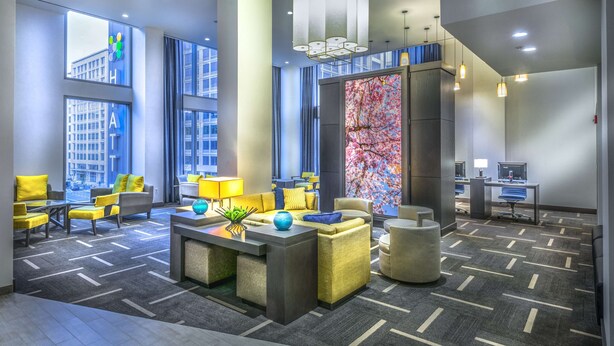 A modern hotel lobby with large windows, a reception desk, seating area, and a decorative wall. - Hyatt Place Washington DC/National Mall (Washington)