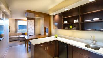 Una cocina moderna con armarios de madera, lavavajillas integrado y un comedor con sofá y mesa.