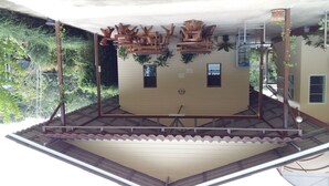 Un espace extérieur abrité, doté d’une structure en bois et agrémenté de plantes.