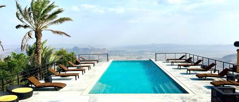 Alberca al aire libre y camastros