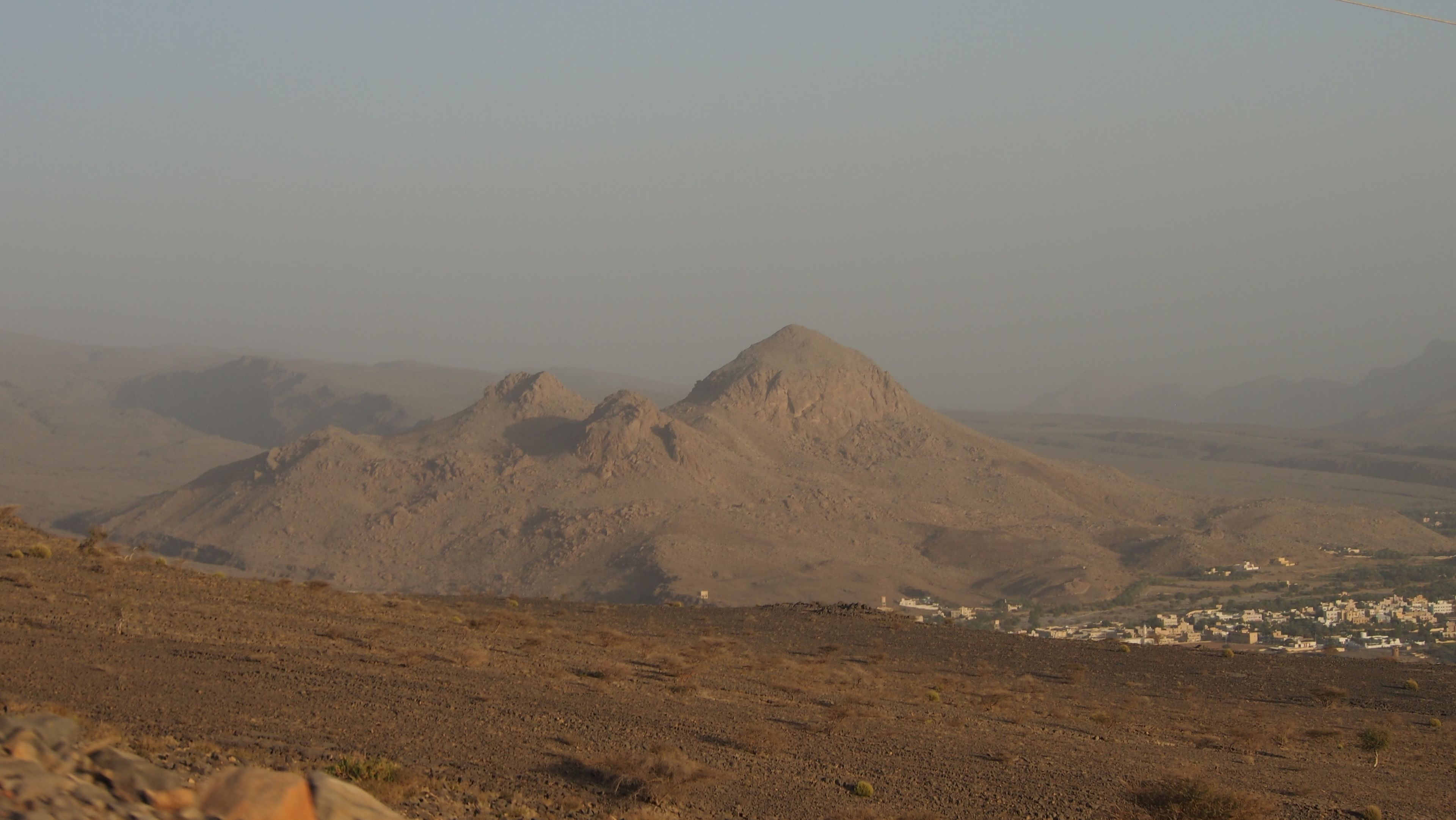 A mountainous landscape with a small settlement in the valley.