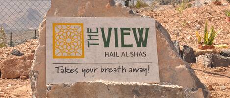A sign with the text "The View" and "Hail Al Shas" with a tagline "Takes your breath away!"