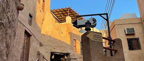 Una calle estrecha con escalones de piedra que llevan a un edificio con un cartel que indica un hotel.