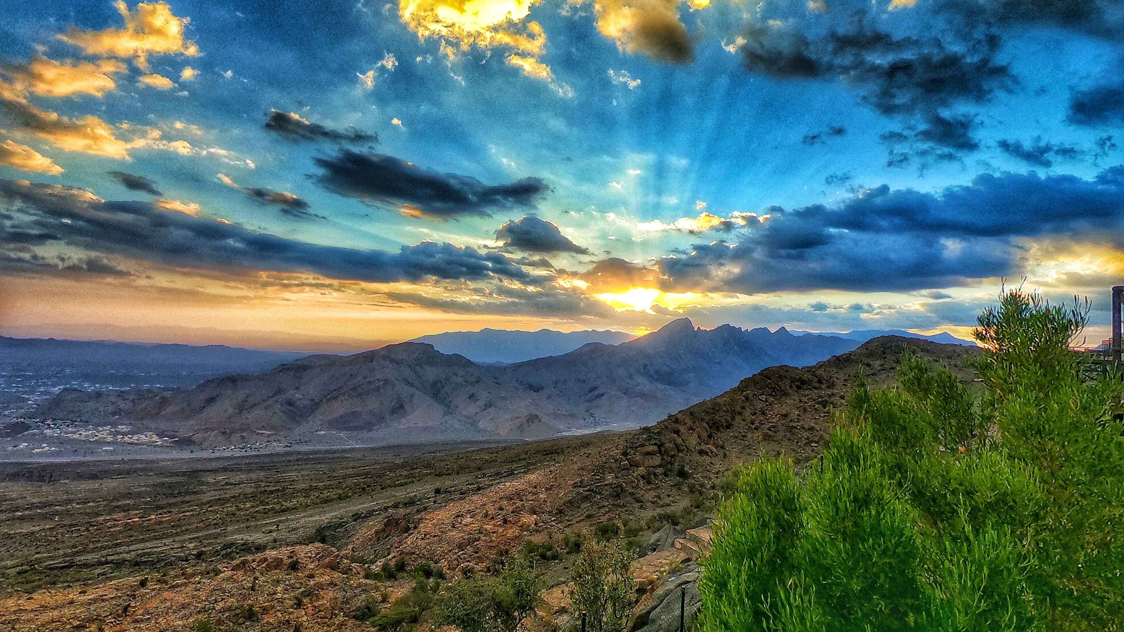 Un paisaje montañoso con un atardecer.