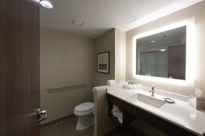 A modern bathroom with a toilet, sink, and mirror. - Holiday Inn Express & Suites St John's Airport by IHG (St. John's)