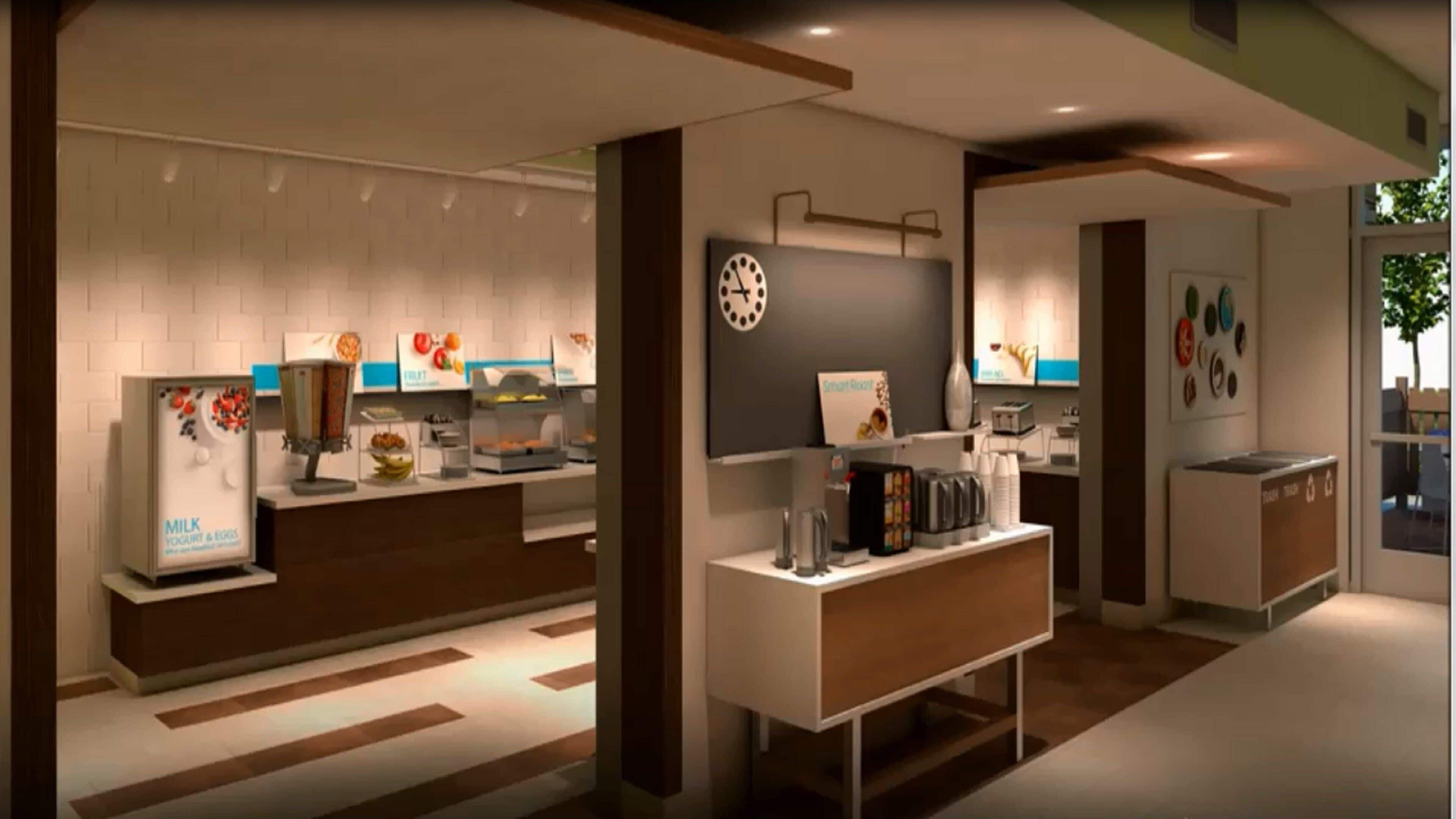 Una cocina moderna con cafetera integrada, un reloj y una exposición de frutas.